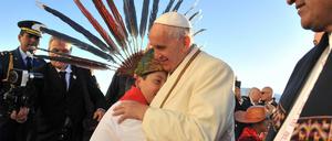 Papst Franziskus umarmt einen Jungen bei seiner Ankunft in Bolivien. Rechts im Bild: Präsident Evo Morales. 