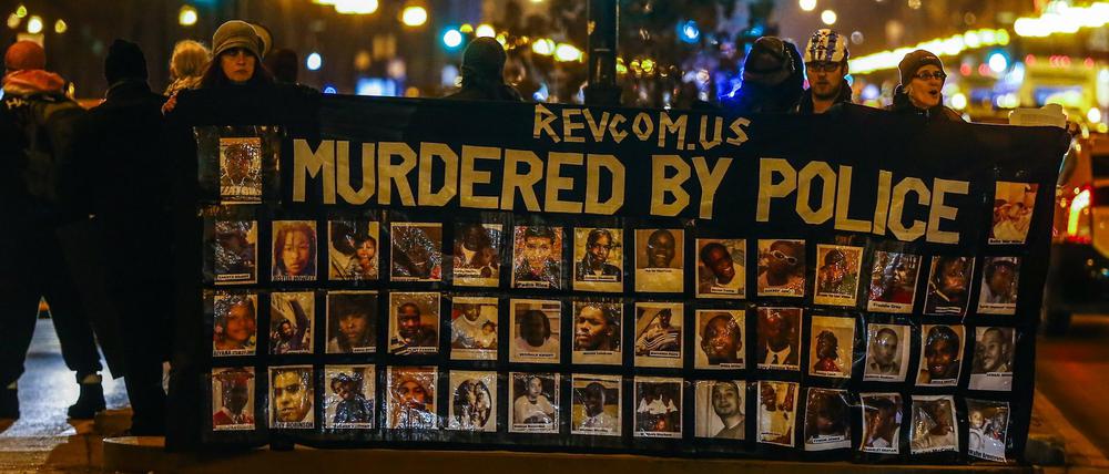 Demonstranten in Chicago halten am Dienstag ein Banner mit Bildern von angeblich von Polizisten ermordeten Schwarzen. 