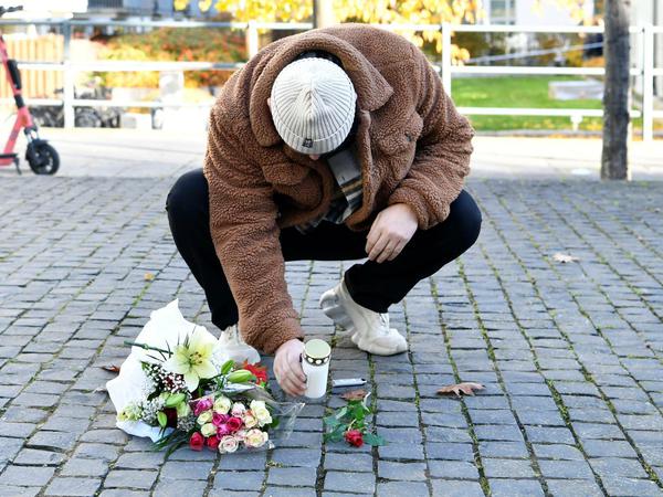 Ein Mann legt Blumen nieder, am Tatort an dem der schwedische Rapper Einar erschossen wurde.