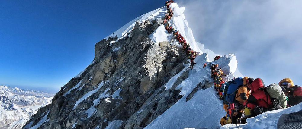 Bergsteiger stehen Schlange, um den Gipfel des Mount Everest zu erreichen. 