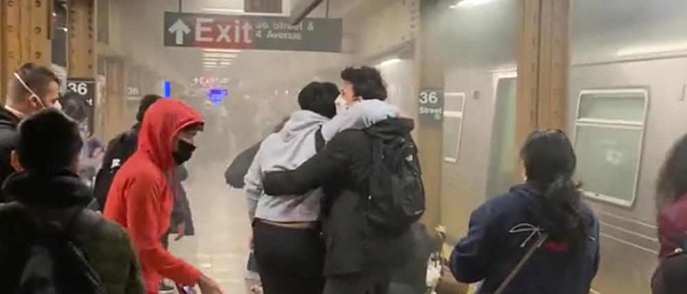 Menschen helfen weiteren verletzten Personen an einer U-Bahn-Station im New Yorker Stadtteil Brooklyn.
