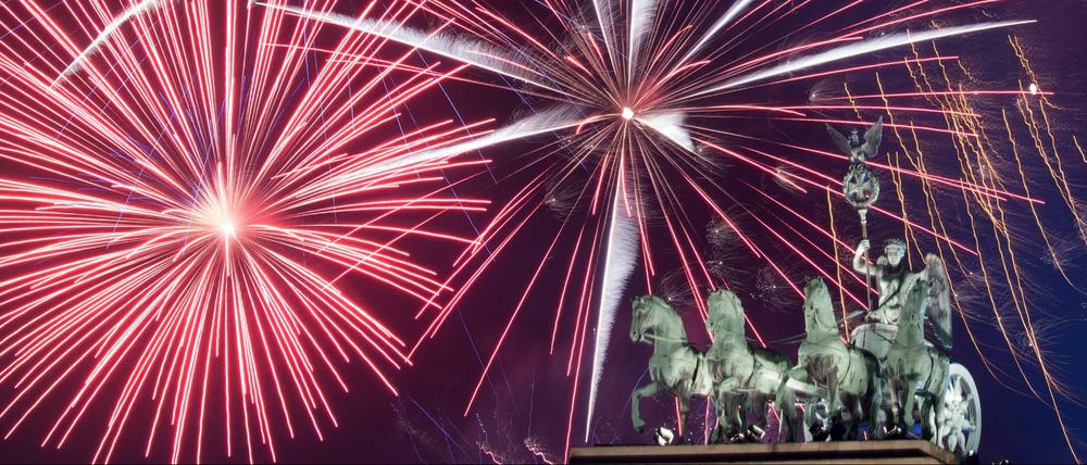 Ein Feuerwerk ist während Deutschlands größter Silvesterparty hinter dem Brandenburger Tor zu sehen.