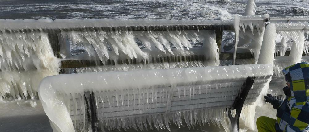 Frost statt Frühling. Ein Panzer aus Eiszapfen hat sich an einer Bank auf der Seebrücke in Göhren an der Ostsee gebildet.