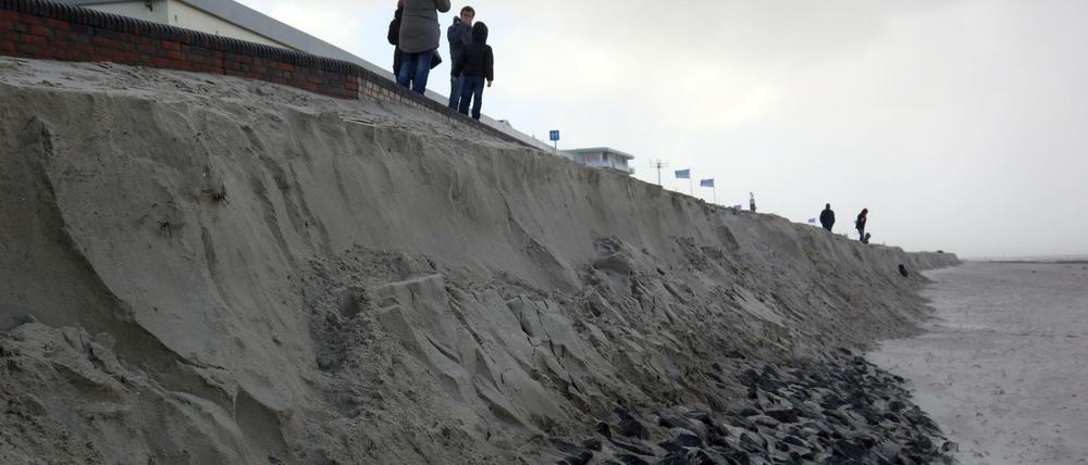 Strand weg: Passanten stehen am 29.10.2017 auf Wangerooge an der Abbruchkante des Strandes. Durch eine Sturmflut des Sturmtiefs «Herwart» und eine wurde ein Teil der Promenade ins Meer gespült.