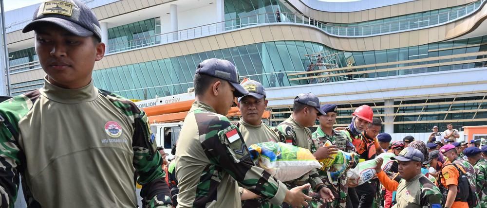 Indonesische Marinesoldaten und Rettungshelfer laden am 28. Dezember Hilfsgüter auf ein Schiff.