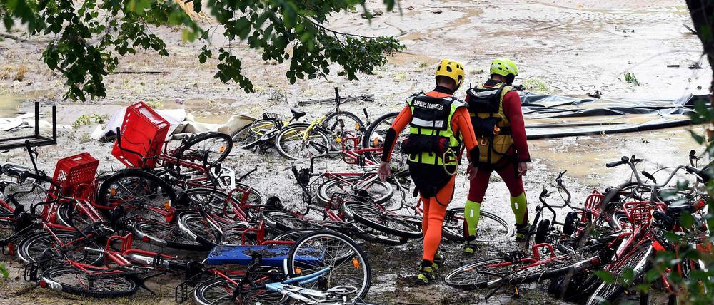 Saint-Julien-de-Peyrolas in Südfrankreich: Rettungskräfte laufen über einen überschwemmten Campingplatz.