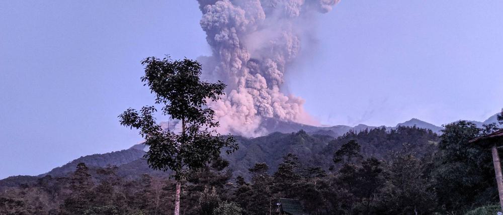 Touristen blicken auf die Rauchsäule über dem Merapi 