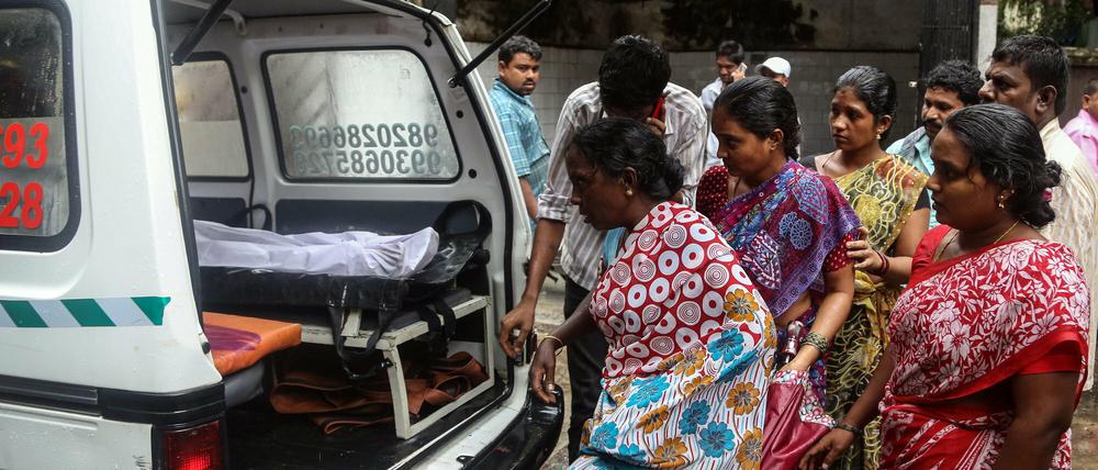 Angehörige der durch gepanschten Schnaps gestorbenen Inder am Freitag auf dem Weg ins Bhagwati Municipal General Hospital in Mumbai. 