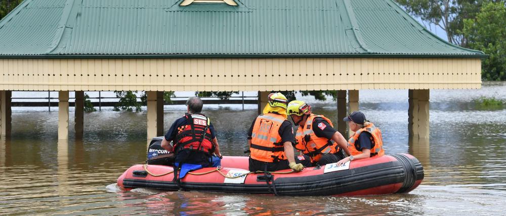 Freiwillige des State Emergency Service (SES) fahren mit einem Rettungsboot durch überflutete Teile von Camden im Südwesten Sydneys.