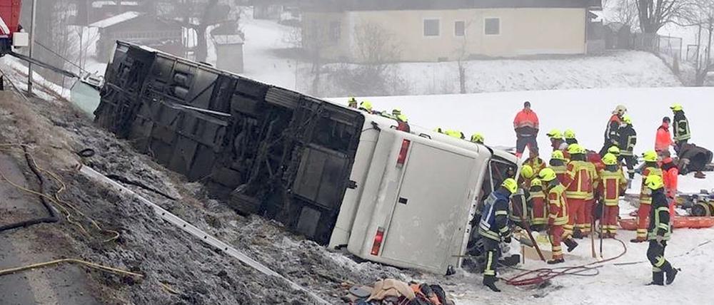 Rettungskräfte stehen auf der Bundesstraße B306 am Ortsausgang von Inzell neben einem umgekippten Reisebus.