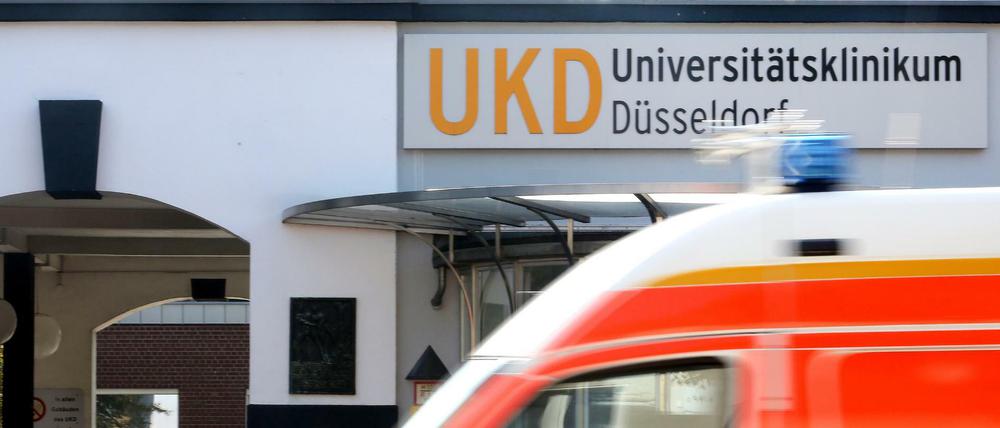 Am Haupteingang zum Universitätsklinikum Düsseldorf fährt ein Krankenwagen vorbei. 