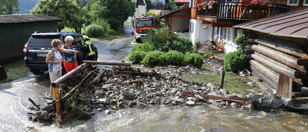 Anwohner betrachten die Schäden durch starke Regenfälle im bayerischen Oberstdorf.