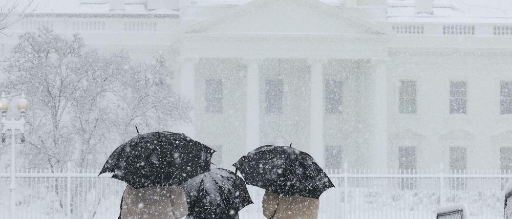 Besucher betrachten das Weiße Haus während eines Schneesturms in Washington, USA, 3. Januar 2022.
