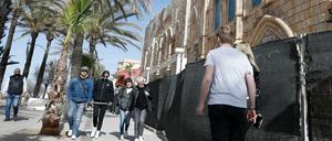 Passanten gehen an der eingezäunten Diskothek "Megapark" am Strand von Arenal auf Mallorca vorbei.