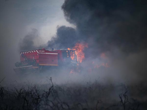 Feuerwehrfahrzeuge, die während eines Waldbrandes außerhalb von Brasparts, Frankreich brennen.
