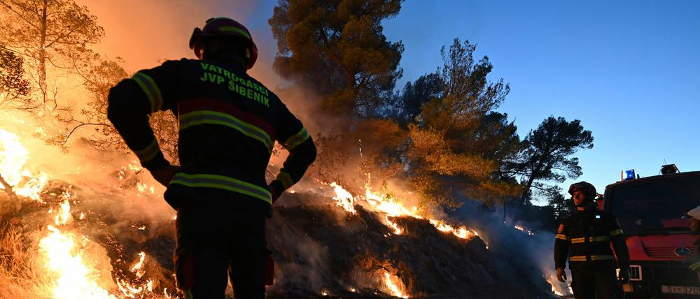 Kroatische Feuerwehrleute beobachten einen Waldbrand in der Nähe von Zaton.