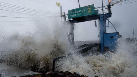 Sturmwellen treffen auf ein Pier an der Küste Thailands. 