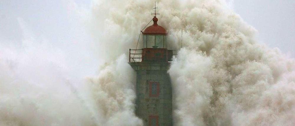 Eine Welle schlägt gegen den Leuchtturm von Porto, Portugal.