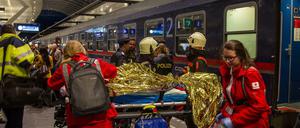 Einsatzkräfte versorgen verletzte Personen an einem Bahnsteig im Salzburger Hauptbahnhof.