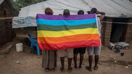 Geflüchtete queere Menschen aus Uganda posieren in einem Flüchtlingslager im kenianischen Kakuma mit einer Regenbogenflagge (Archivbild).