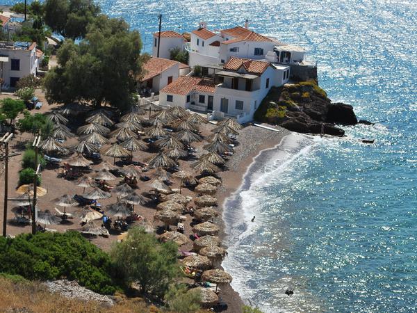 Badegäste entspannen an einem kleinen Strand auf der Ferieninsel Hydra in Griechenland.