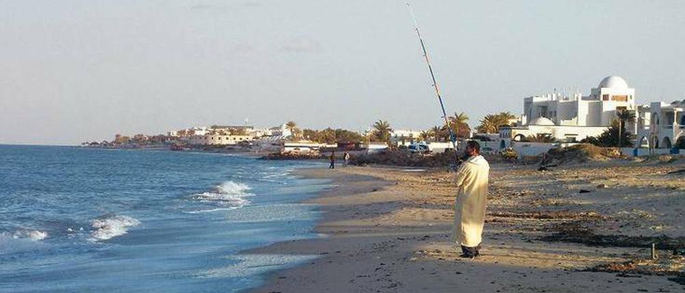 Wenn er könnte, würde sich dieser Mann am Strand der tunesischen Insel Djerba vermutlich gern ein paar Touristen angeln. 