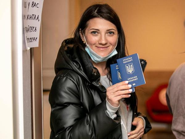 Eine Ukrainerin hält ihren Reisepass hohc.