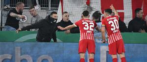 Freiburger Fans verschaffen sich nach dem Münzwurf Zugang zum Innenraum des Stadions. Freiburgs Vincenzo Grifo und Kapitän Christian Günter versuchen, zu beruhigen.