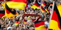 Fußball-WM: Fußballfans feiern beim Public Viewing die deutsche Nationalelf und schwenken Deutschlandfahnen.