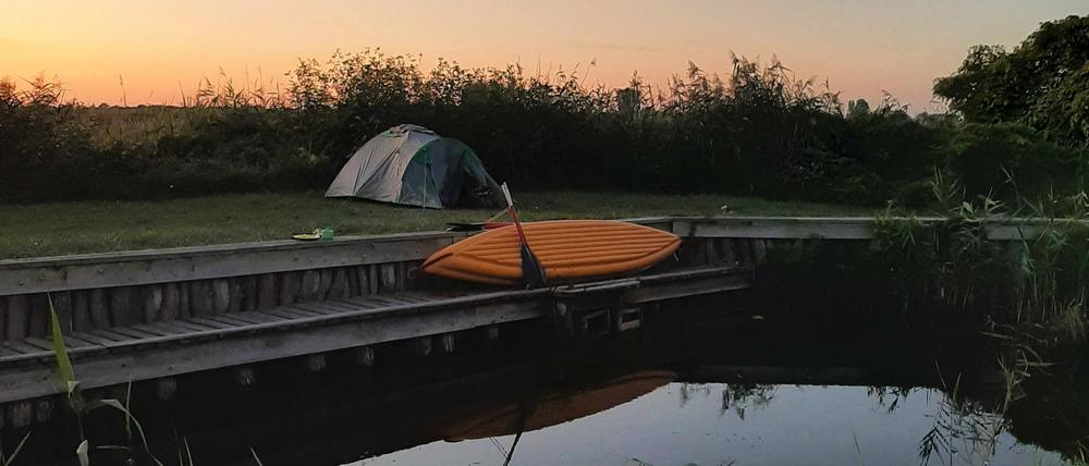 Schlafen am Wasser: Zelt und Boot im Hafen Linum.