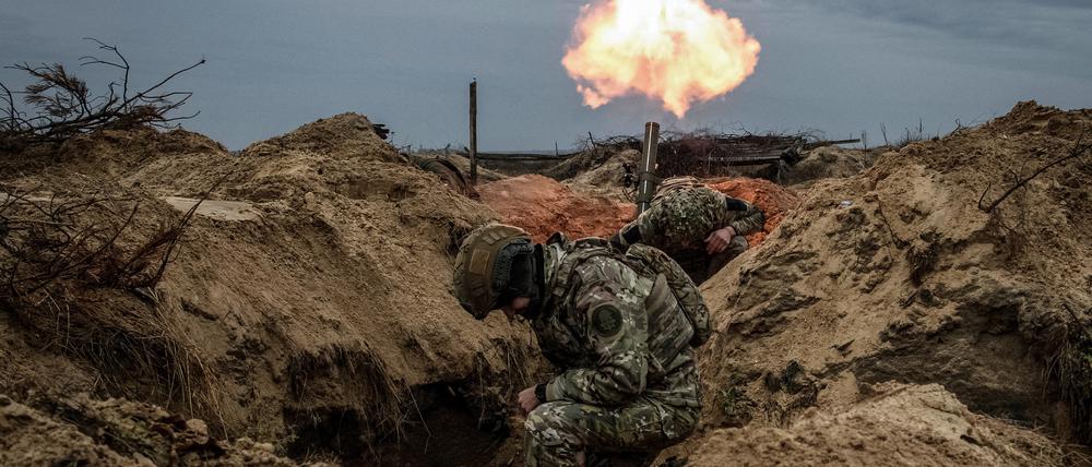 Ukrainische Soldaten feuern aus ihrem Schützengraben.