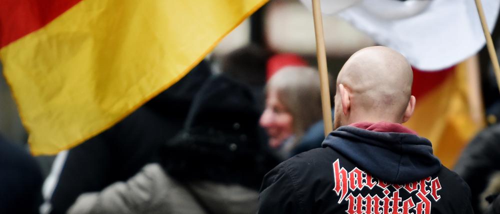 Ein Demonstrant steht während einer Veranstaltung der Partei «Die Rechte» zwischen Deutschlandfahnen. 