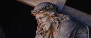 Eine Figur des Jesus Christus mit dem Kreuz ist an einer Fassade in der Bamberger Altstadt zu sehen. Die Kirchen bereiten sich auf Ostern in der Corona-Pandemie vor. Im Bamberger Dom muss man sich für Gottesdienste anmelden. +++ dpa-Bildfunk +++