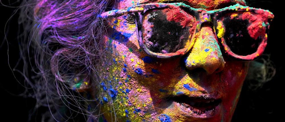 Das Gesicht einer Frau ist mit Farben bemalt, um das Hindu Fest Holi zu feiern. 