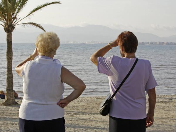 Zwei Rentnerinnen bei Sonnenuntergang am Strand von El Arenal auf Mallorca.
