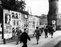 Wer behält da den Überblick? Passanten in Frankfurt am Main neben einer Plakatwand mit Wahlwerbung für die Wahlen im September 1953.