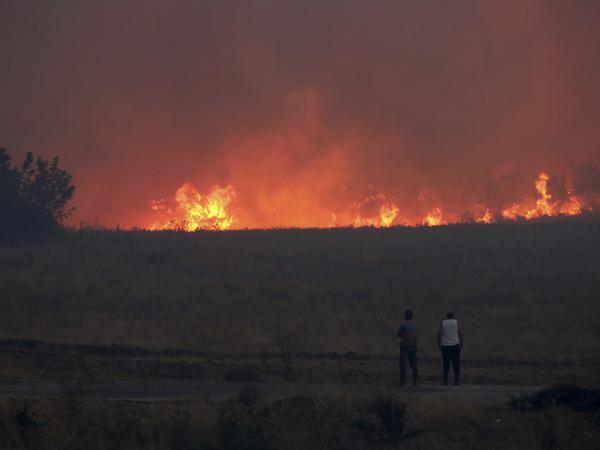 Anwohner beobachten im äußersten Nordosten Griechenlands einen Waldbrand. 