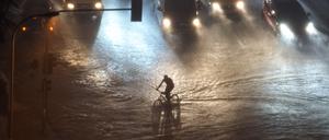Ein Radfahrer fährt im Western der Türkei durch das Hochwasser. 