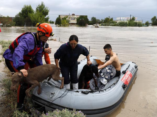 Feuerwehrleute mit einem Schlauchboot evakuieren Menschen und ihre Hunde am 6.9.2023 aus überfluteten Gebäuden.