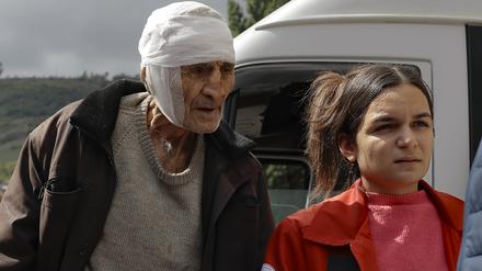 Ein verwundeter armenischer Mann namens Sasha, 84 Jahre alt aus Stepanakert in Bergkarabach, wird von Freiwilligen bei seiner Ankunft in der armenischen Stadt Goris in der Region Syunik, Armenien gestützt.