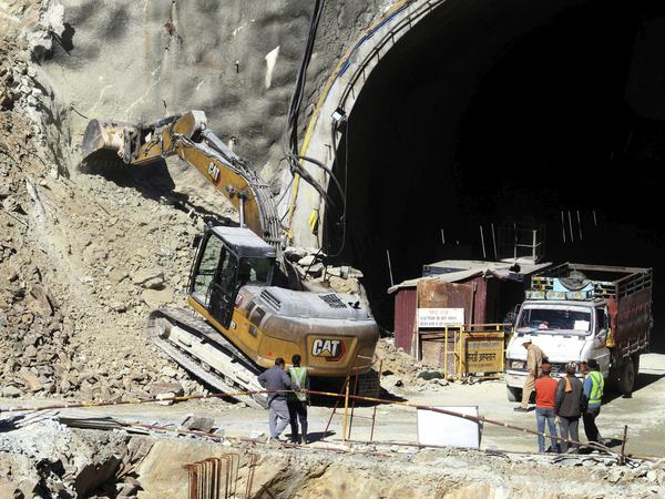 Ein Bagger arbeitet am Eingang eines im Bau befindlichen Straßentunnels, der  im Nordern Indiens (Bundesstaat Uttarakhand) eingestürzt ist. 