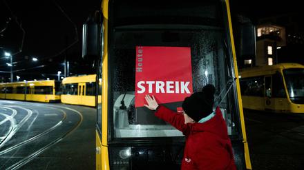 Eine Mitarbeiterin klebt ein Poster, auf dem «STREIK» steht, auf eine Bahn im Depot der Ruhrbahn in Essen. In dem bundesweit in regionalen Verhandlungen laufenden Tarifkonflikt des öffentlichen Nahverkehrs hatte die Gewerkschaft Verdi Beschäftigte der Branche in mehr als 80 Städten zu einem Warnstreik aufgerufen. 