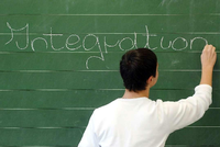 Ein Schüler schreibt das Wort Integration an die Tafel.