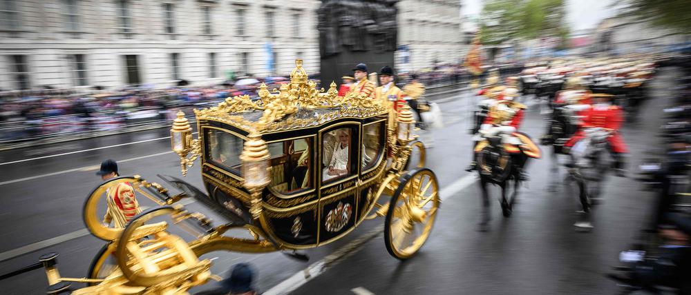 Der britische König Charles III. und seine Königsgemahlin Camilla fahren während der „Königsprozession“ in der Staatskutsche vom Buckingham Palace zur Westminster Abbey – hier wird die Krönung stattfinden. 