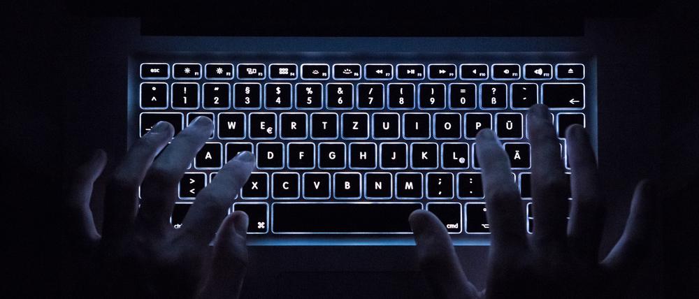 Ein Mann benutzt die beleuchtete Tastatur eines Notebooks
