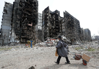 Eine Bewohnerin von Mariupol geht durch die zerstörten Straßen Foto: Alexander Ermochenko/REUTERS