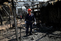 Ein Helfer läuft nach dem Brand durch eine Trümmerlandschaft Foto: REUTERS/Alkis Konstantinides