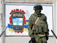 Ein Soldat in einer Uniform ohne Hoheitszeichen bewacht Anfang März 2014 eine ukrainische Militärbasis auf der Krim. Foto: Vasily Fedosenko/Reuters