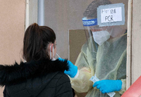 Einer Frau wird auf einer Teststation im süddeutschen Ludwigsburg eine Probe für einen PCR-Test entnommen. Foto: AFP/THOMAS KIENZLE