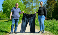 Michael Wirtz (l) und Meike Preußner halten eine Hose in Größe 60 in den Händen. Beide engagieren sich in der Adipositas-Selbsthilfe. Foto: Philipp Schulze/dpa